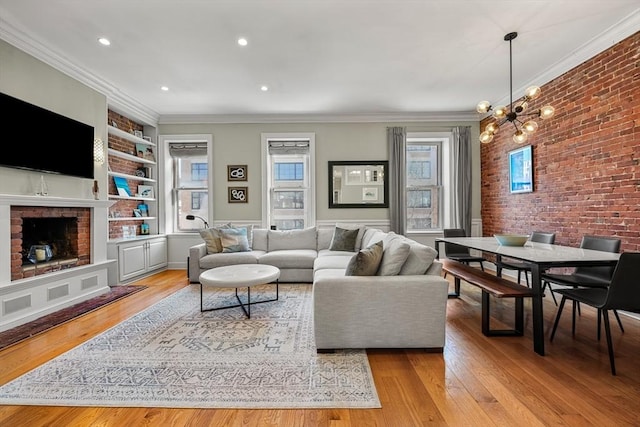 living room featuring crown molding, brick wall, light wood-style flooring, and built in features