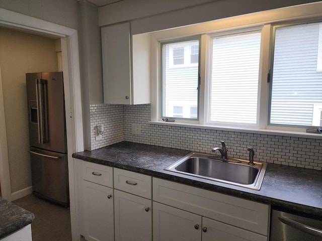 235 Common St, Watertown, MA 02472 - kitchen featuring stainless steel appliances, a sink, dark countertops, and white cabinets