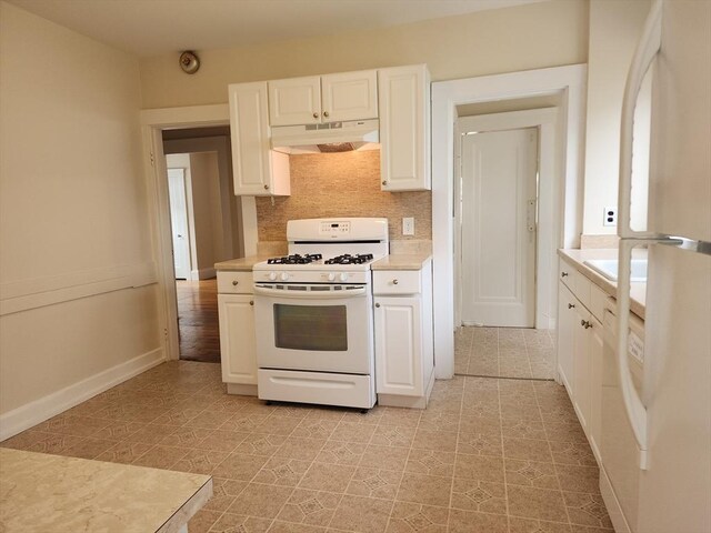 235 Common St, Watertown, MA 02472 - kitchen with white appliances, under cabinet range hood, light countertops, and white cabinetry
