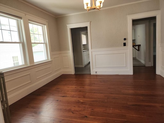235 Common St, Watertown, MA 02472 - unfurnished dining area featuring a chandelier, crown molding, dark wood finished floors, wainscoting, and a decorative wall