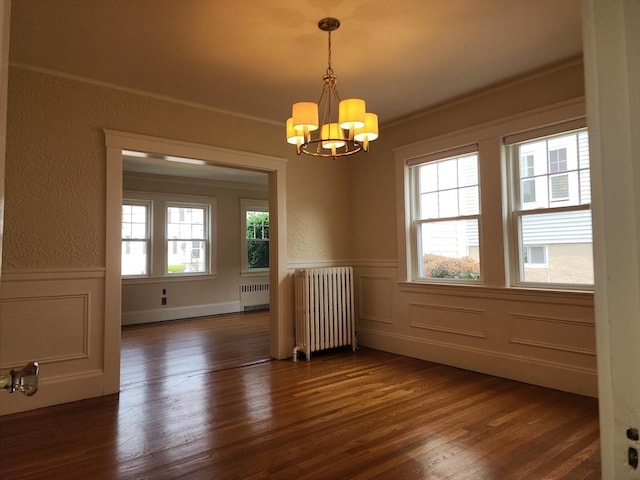235 Common St, Watertown, MA 02472 - empty room featuring radiator, a chandelier, dark wood-type flooring, a decorative wall, and a wainscoted wall