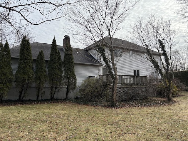 view of home's exterior with a wooden deck and a lawn