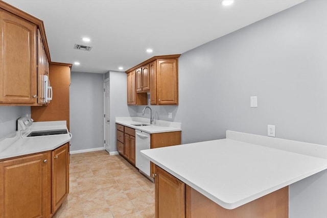 404 Broadway Unit 107, Lynn, MA 01904 - kitchen with white appliances, a peninsula, light countertops, recessed lighting, and brown cabinetry