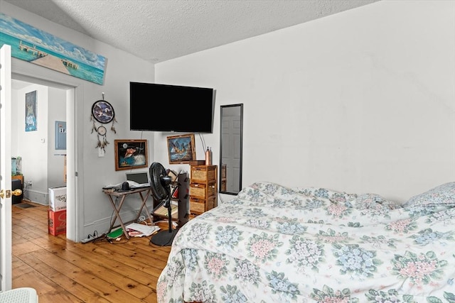 bedroom featuring hardwood / wood-style flooring and a textured ceiling