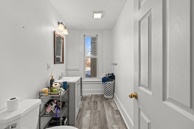 bathroom with hardwood / wood-style flooring, vanity, and toilet