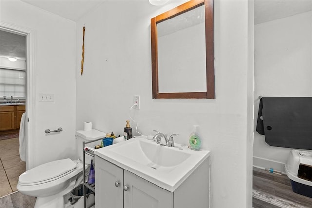 bathroom featuring vanity, wood-type flooring, and toilet