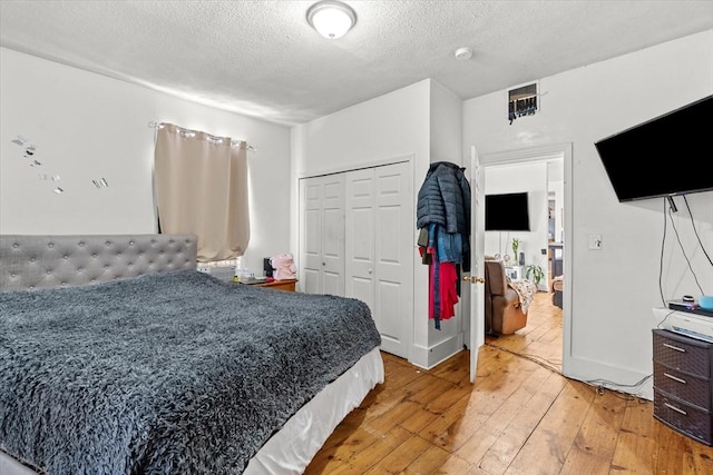 bedroom with hardwood / wood-style flooring, a closet, and a textured ceiling