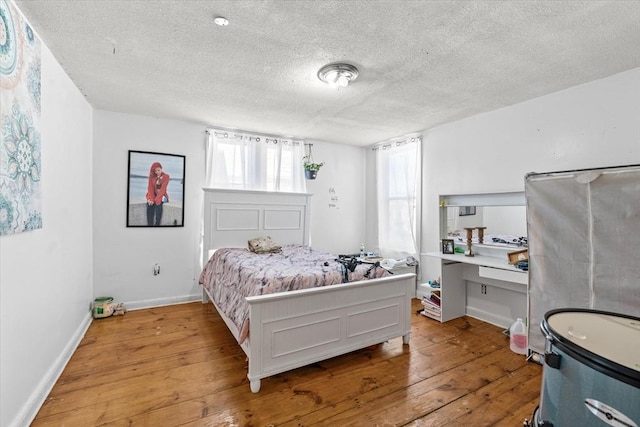 bedroom with light hardwood / wood-style flooring and a textured ceiling