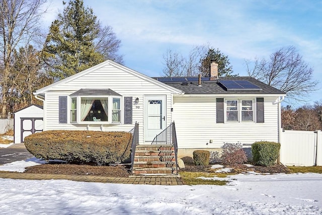 view of front of home featuring a shed and solar panels