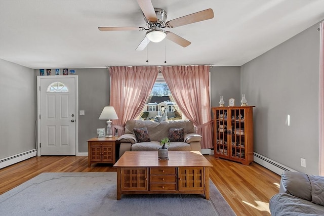 living room featuring a baseboard radiator, light hardwood / wood-style floors, and ceiling fan