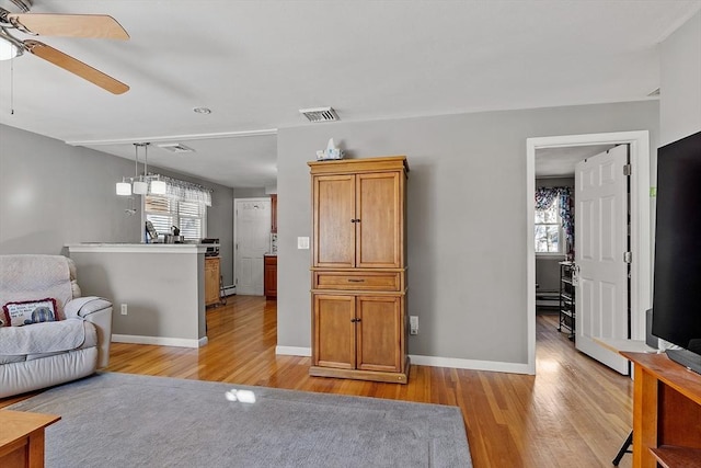 living room featuring ceiling fan, plenty of natural light, and light hardwood / wood-style flooring