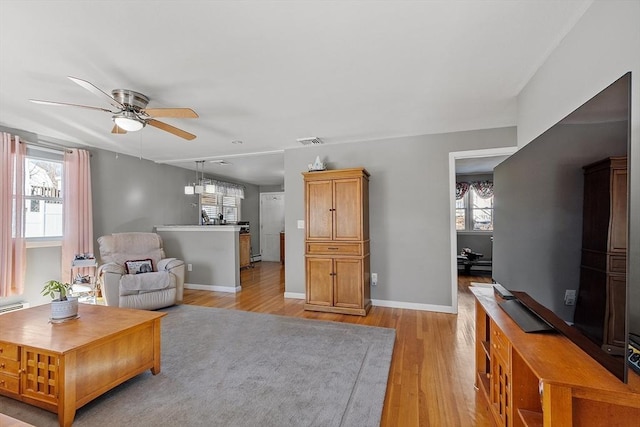 living room featuring ceiling fan and light hardwood / wood-style floors