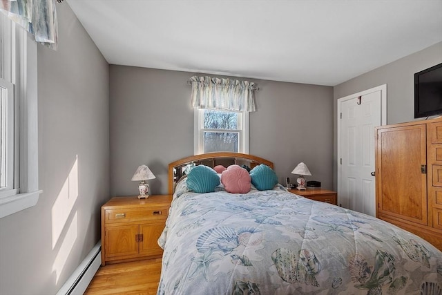 bedroom featuring baseboard heating and light wood-type flooring