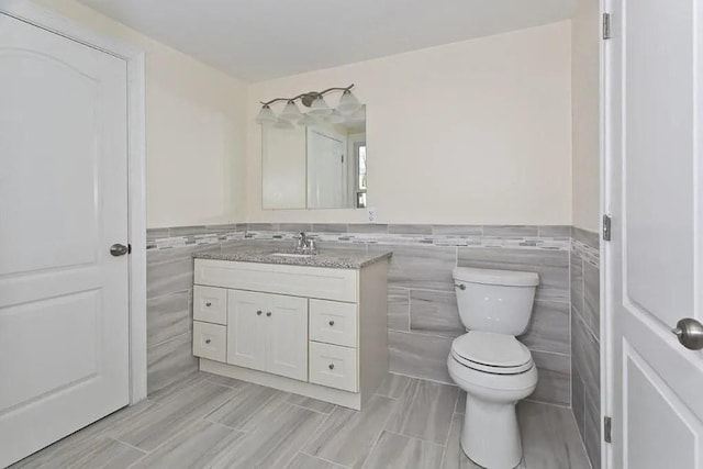 15 Phillips St, Weymouth, MA 02188 - bathroom featuring tile walls, vanity, toilet, and wainscoting