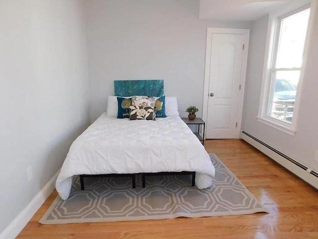 15 Phillips St, Weymouth, MA 02188 - bedroom featuring baseboard heating, light wood-type flooring, and baseboards