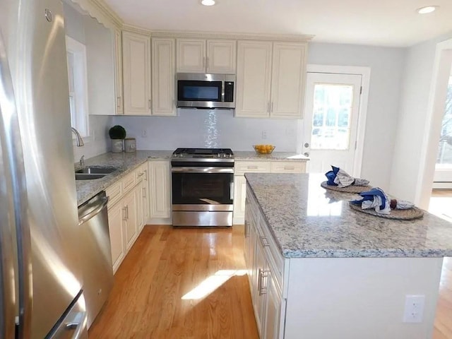 15 Phillips St, Weymouth, MA 02188 - kitchen with stainless steel appliances, a sink, light wood-style flooring, light stone counters, and recessed lighting