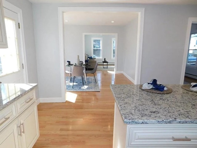 15 Phillips St, Weymouth, MA 02188 - kitchen with light wood finished floors, baseboards, light stone countertops, and a baseboard radiator