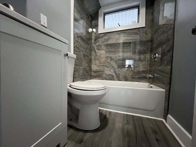 full bath with shower / bath combination, toilet, and wood finished floors