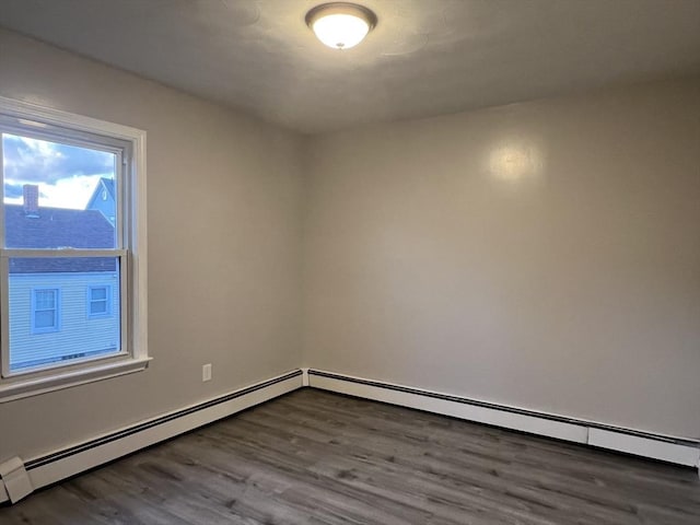 empty room featuring baseboard heating and dark wood-style flooring