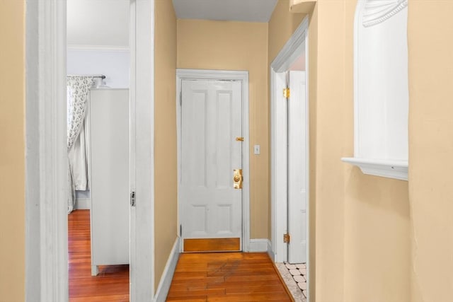 hall featuring baseboards and wood finished floors