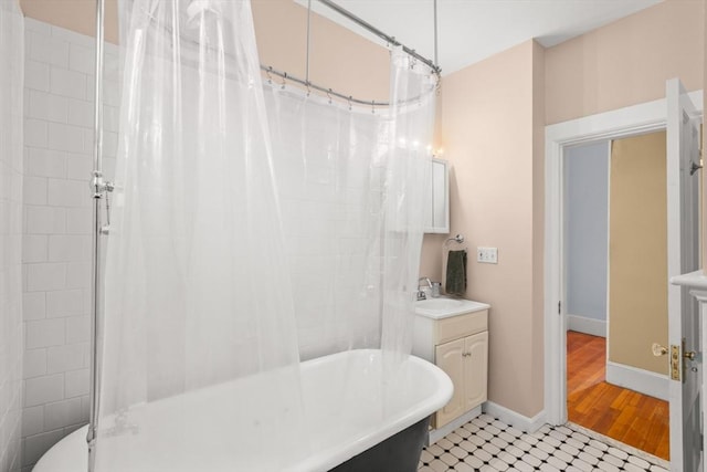 full bathroom with a soaking tub, baseboards, vanity, and a shower with shower curtain