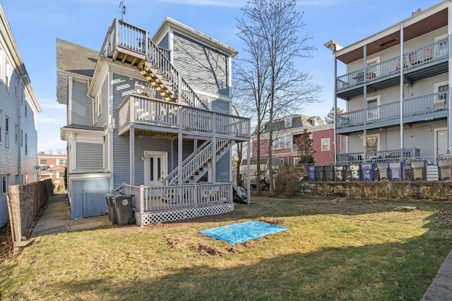 rear view of house with fence, a deck, and a yard