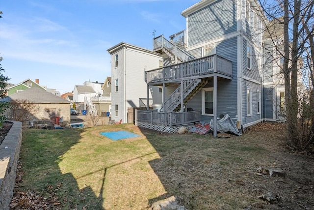 rear view of house with stairway, a lawn, and a wooden deck