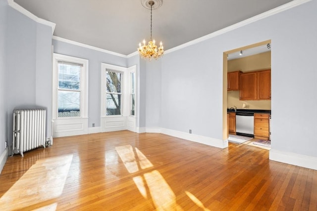 unfurnished dining area with crown molding, light wood-style flooring, radiator heating unit, a chandelier, and baseboards