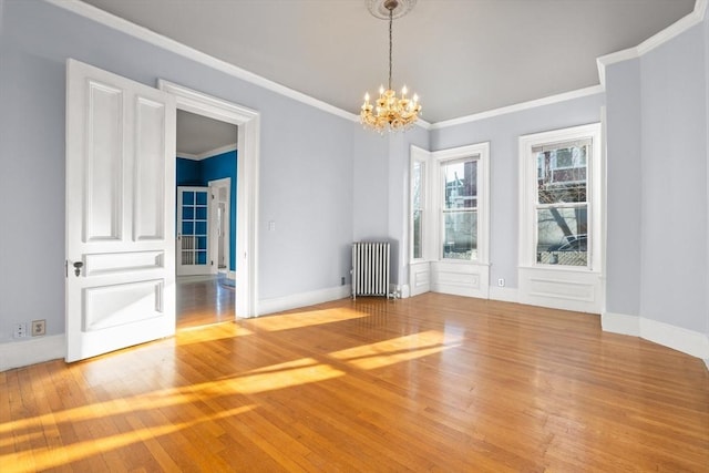 unfurnished dining area with radiator, a chandelier, hardwood / wood-style floors, and ornamental molding