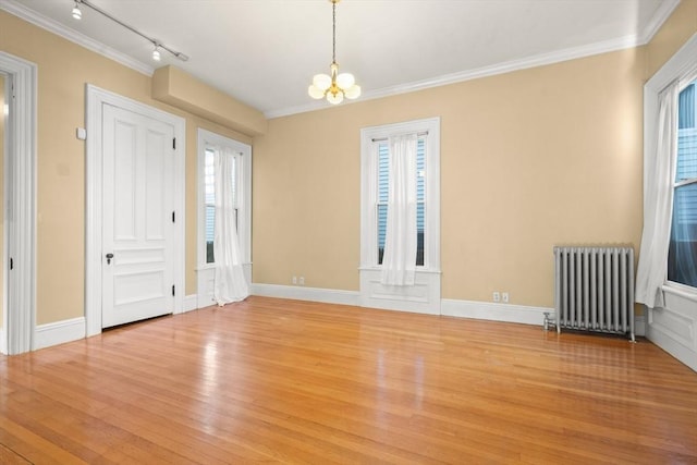 entrance foyer with light wood-type flooring, a healthy amount of sunlight, a notable chandelier, and radiator heating unit