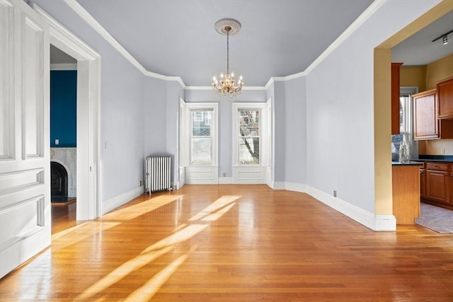 unfurnished dining area with radiator, light wood-style flooring, a premium fireplace, and a notable chandelier