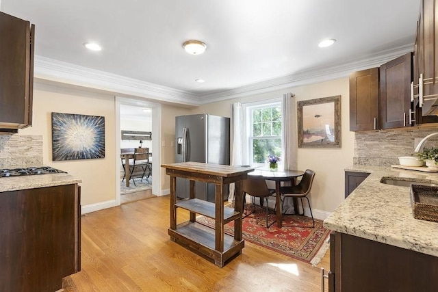 32 Jewett St, Boston, MA 02131 - kitchen featuring a sink, dark brown cabinets, decorative backsplash, baseboards, and ornamental molding