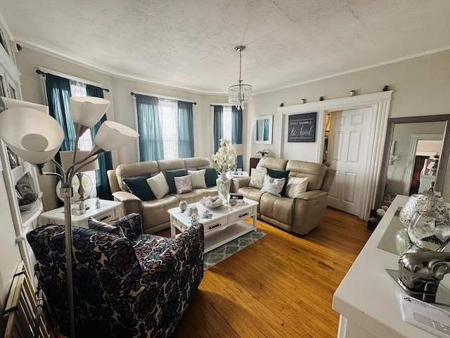 living room with an inviting chandelier, wood-type flooring, and a textured ceiling