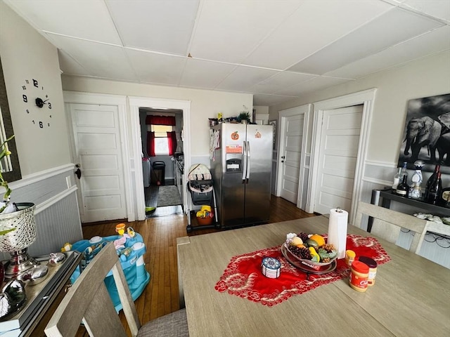 kitchen featuring wainscoting, wood finished floors, and stainless steel fridge with ice dispenser