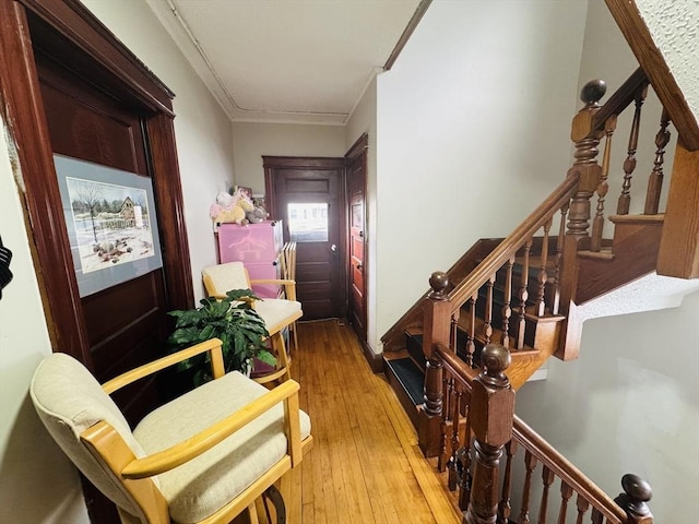 hallway with stairs, wood-type flooring, and ornamental molding