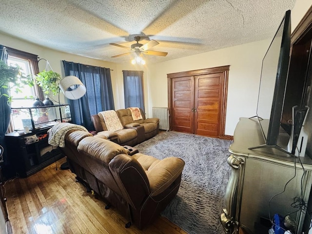 living room featuring a textured ceiling, ceiling fan, and hardwood / wood-style floors