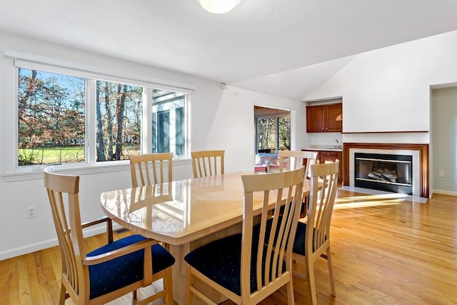 dining area with light hardwood / wood-style flooring and lofted ceiling