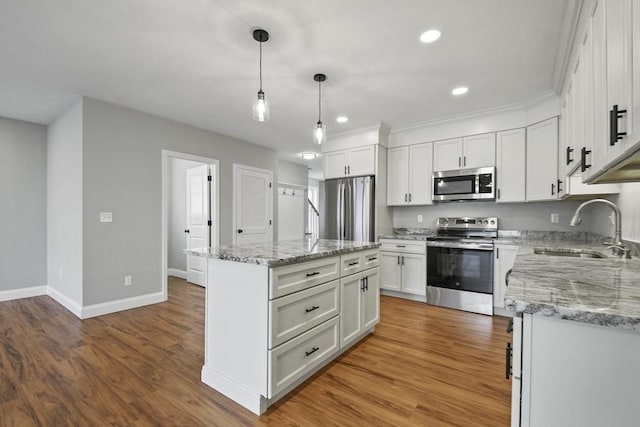 kitchen with sink, white cabinetry, a kitchen island, pendant lighting, and stainless steel appliances