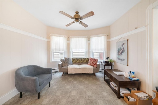 sitting room featuring a baseboard radiator, ceiling fan, and light colored carpet