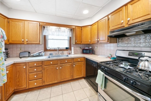 kitchen with light tile patterned floors, sink, a paneled ceiling, and black appliances