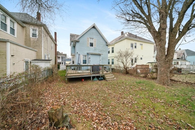 rear view of house featuring a deck and a lawn