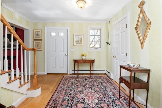 entryway featuring baseboards, stairway, ornamental molding, wood finished floors, and a baseboard heating unit