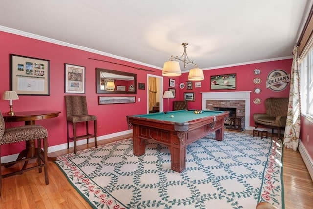 recreation room featuring ornamental molding, baseboards, and wood finished floors