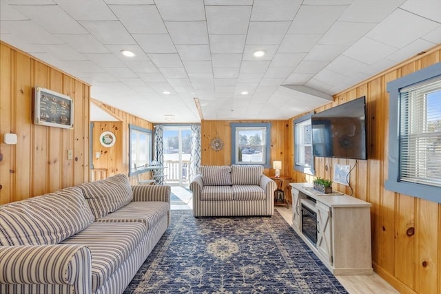 living room with a healthy amount of sunlight and wood walls