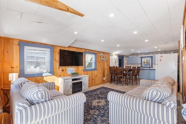 living room with vaulted ceiling and wooden walls