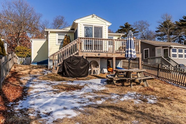 snow covered property with a wooden deck