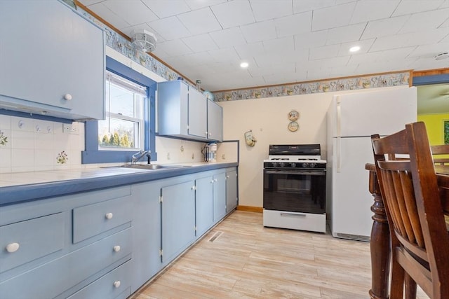 kitchen with sink, backsplash, white appliances, and light hardwood / wood-style flooring