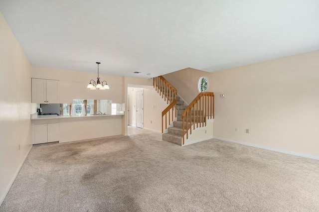 19 Garden St Unit 107, Danvers, MA 01923 - unfurnished living room featuring a chandelier, stairway, and light colored carpet