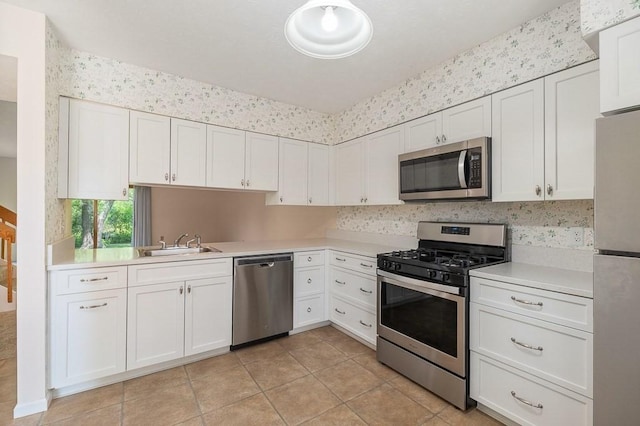 19 Garden St Unit 107, Danvers, MA 01923 - kitchen featuring appliances with stainless steel finishes, light countertops, light tile patterned floors, and white cabinets
