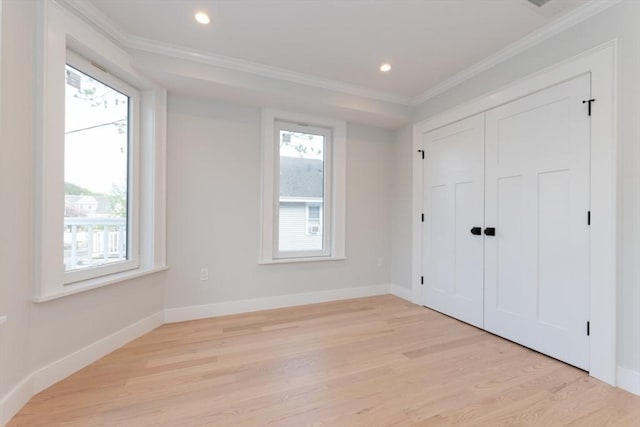 unfurnished bedroom featuring crown molding, light wood finished floors, baseboards, recessed lighting, and a closet